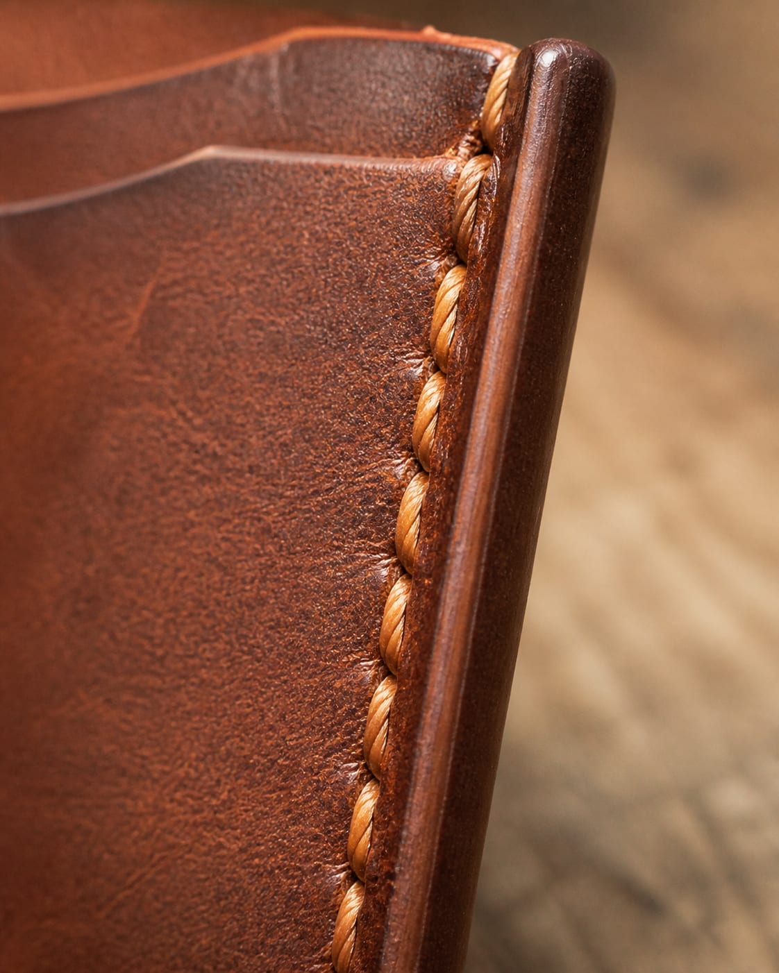 Close-up of card holder side seam stitching and burnished edge.